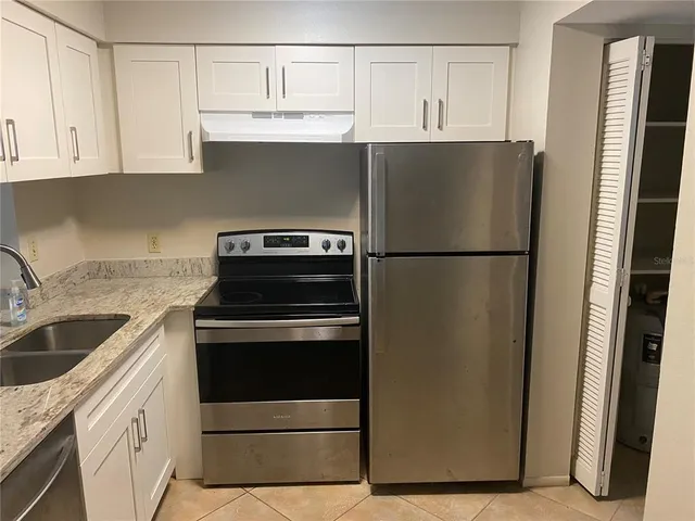 a kitchen with a refrigerator sink and cabinets