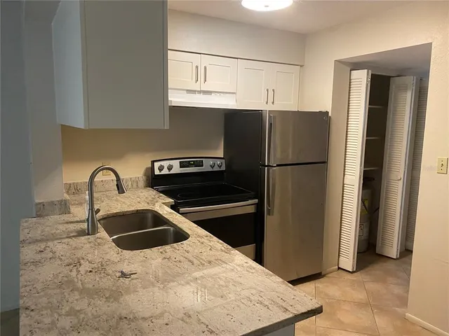 a kitchen with stainless steel appliances granite countertop a refrigerator sink and stove