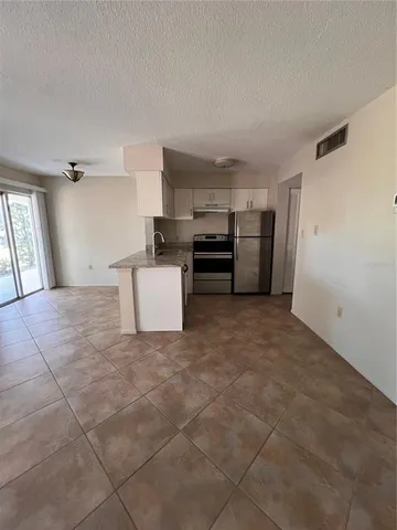 a view of kitchen and refrigerator in cabinet