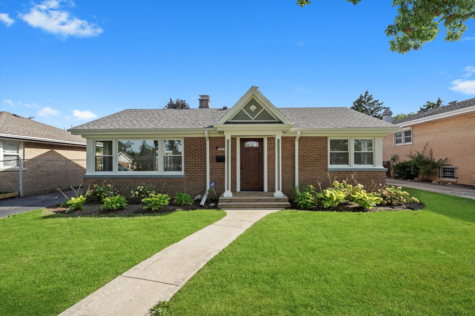 a front view of a house with a garden and plants