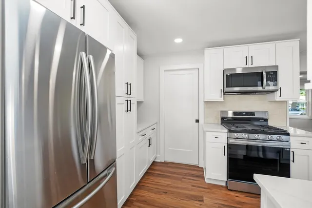 a kitchen with stainless steel appliances a refrigerator stove and microwave
