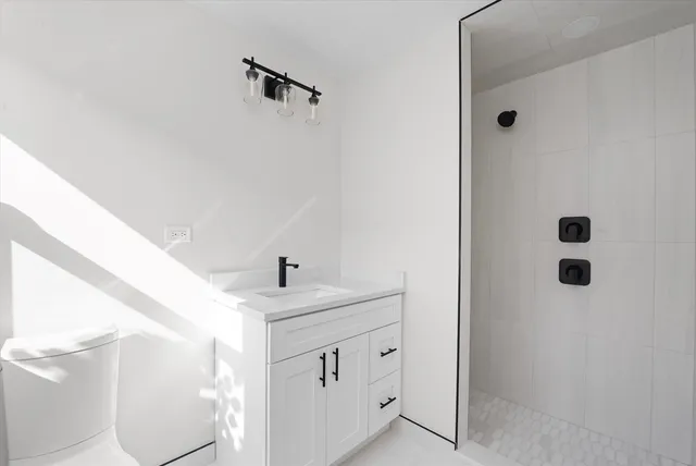 a bathroom with a sink a toilet and shower