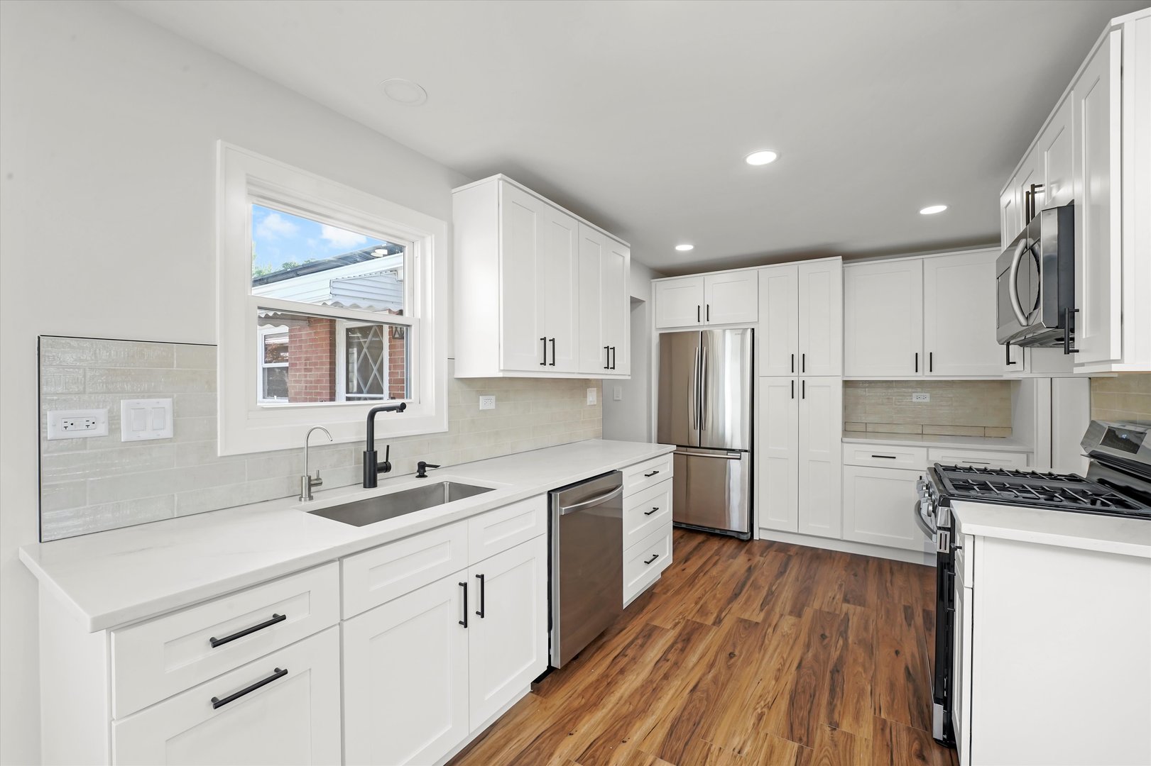 5809 Huron Street Berkeley, IL 60163 - Photo 7 of 26 a kitchen with a sink a refrigerator and wooden floor
