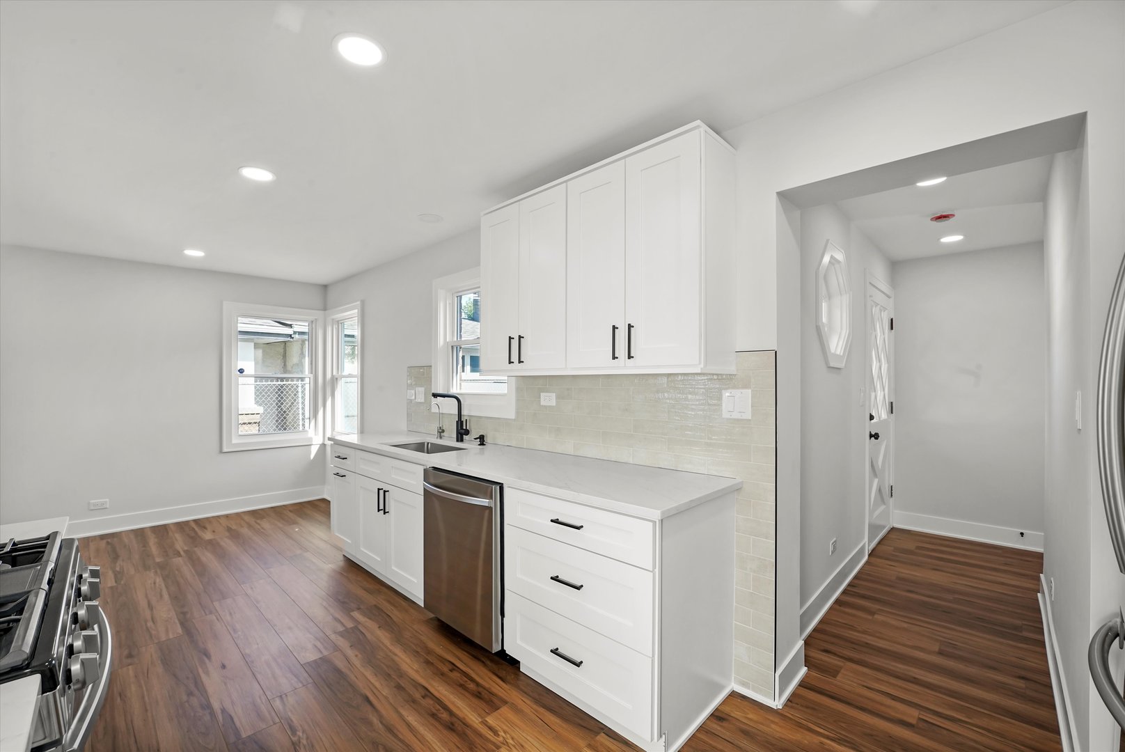 5809 Huron Street Berkeley, IL 60163 - Photo 8 of 26 a kitchen with stainless steel appliances a white stove top oven and white cabinets