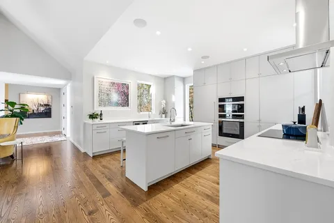 a kitchen that has a lot of cabinets in it and wooden floor