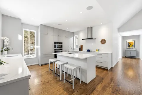 a large white kitchen with a table and chairs in it