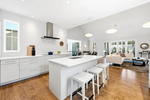 a large white kitchen with lots of counter space a sink and appliances