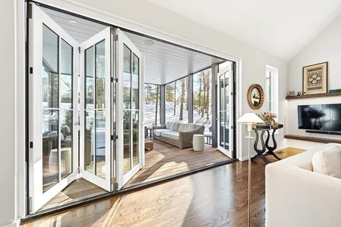 a living room with furniture a fireplace and a floor to ceiling window