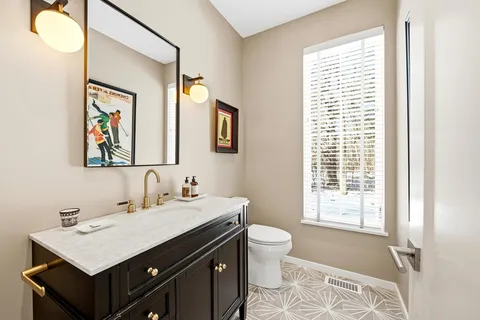 a bathroom with a toilet sink and mirror