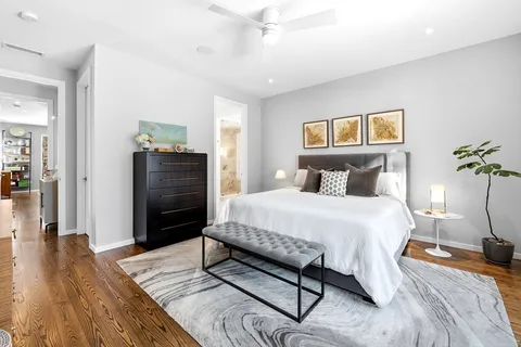 a bedroom with a bed and wooden floor