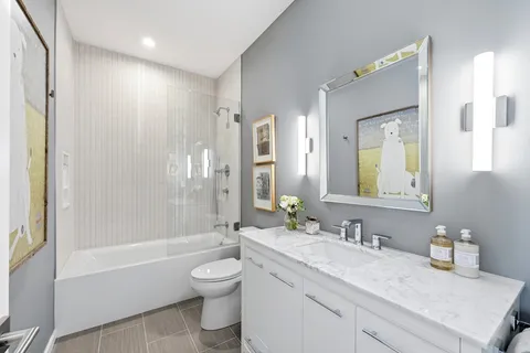 a bathroom with a granite countertop sink toilet tub and shower