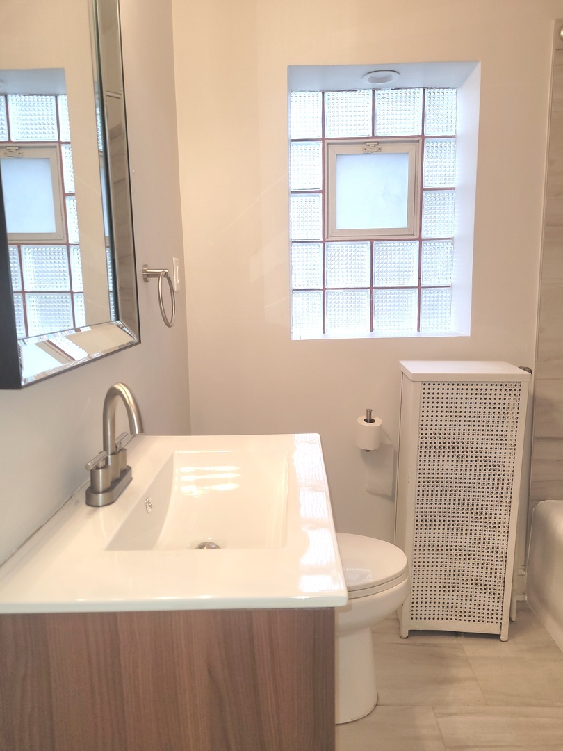 2336 East 68th Street, Unit 2 Chicago, IL 60649 - Photo 13 of 17 a bathroom with a sink a toilet and a window