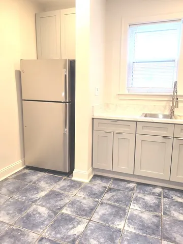 a view of empty room with a refrigerator