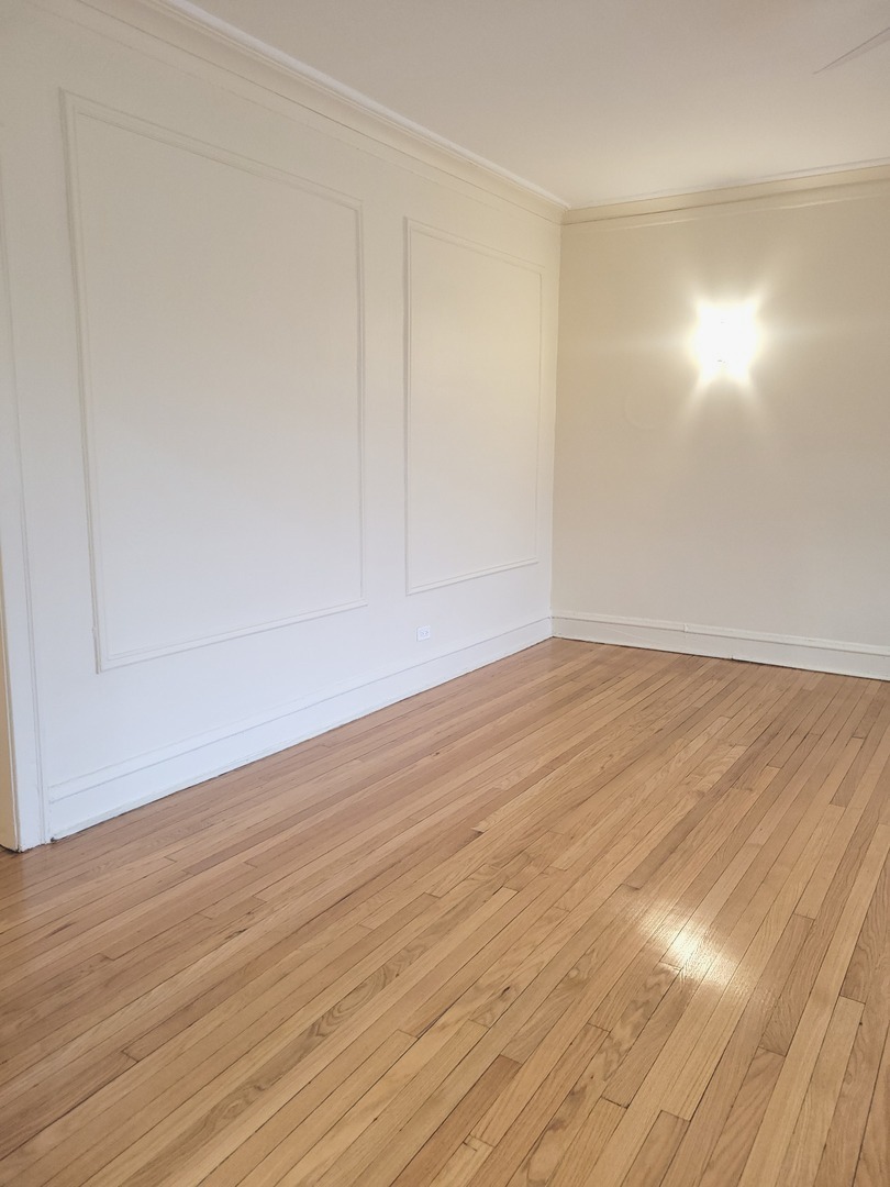 2336 East 68th Street, Unit 2 Chicago, IL 60649 - Photo 7 of 17 a view of an empty room with wooden floor
