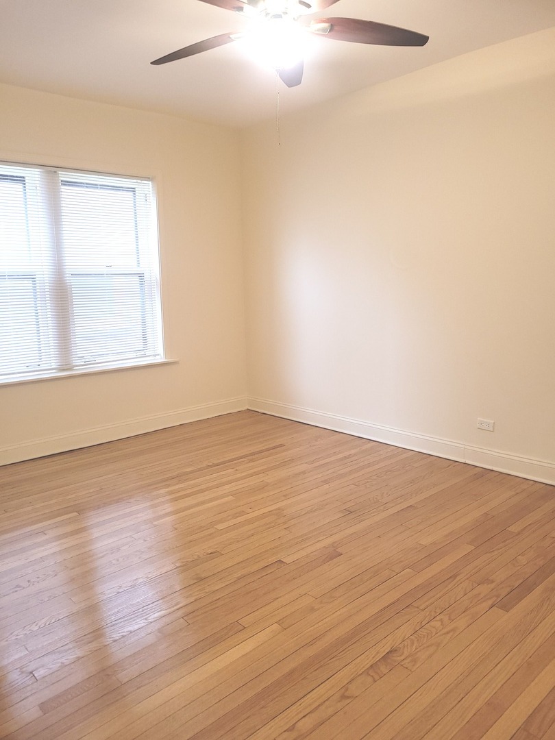 2336 East 68th Street, Unit 2 Chicago, IL 60649 - Photo 9 of 17 an empty room with wooden floor and windows