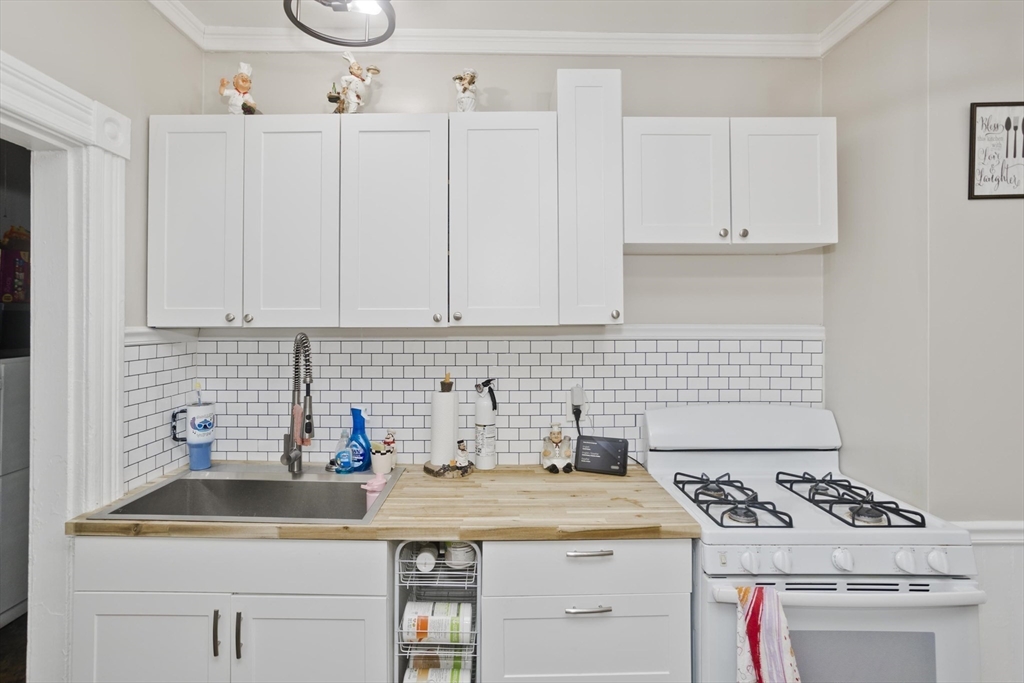 37 Phoenix Street Springfield, MA 01104 - Photo 9 of 39 a kitchen with white cabinets sink and stove