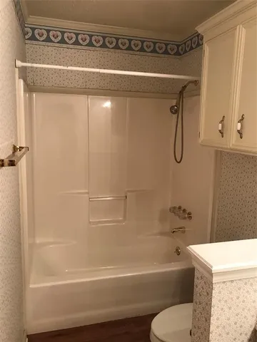 a bathroom with a shower a toilet and a sink