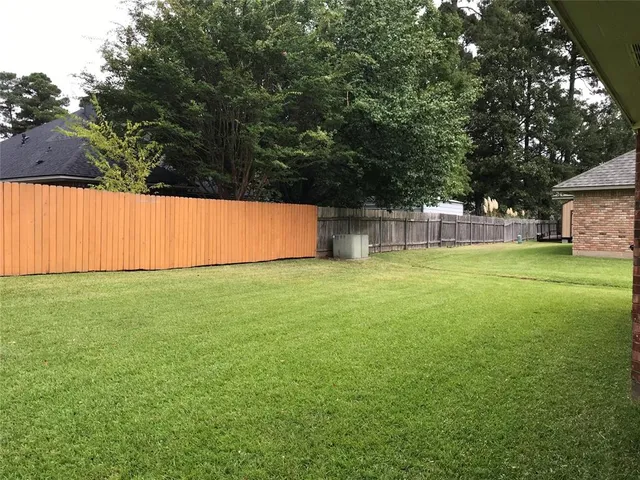 a view of a yard with a house and large trees