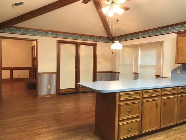 a kitchen with a table chairs and wooden floor