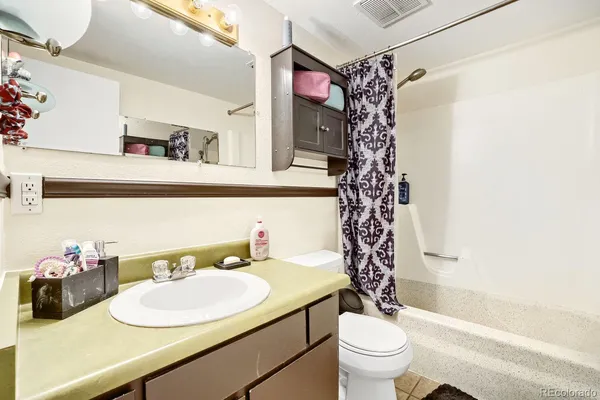 a bathroom with a sink a toilet and a shower curtain