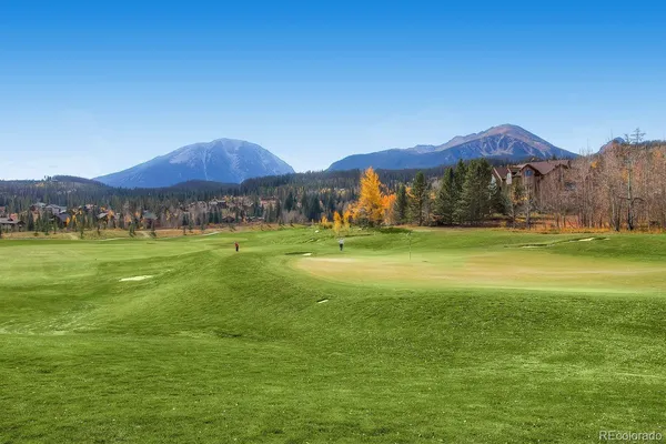 a view of a green field with mountains in the background