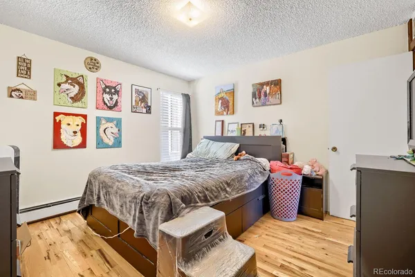 a bedroom with a bed and wooden floor
