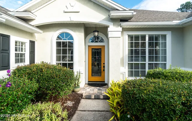 a living room with furniture and floor to ceiling windows
