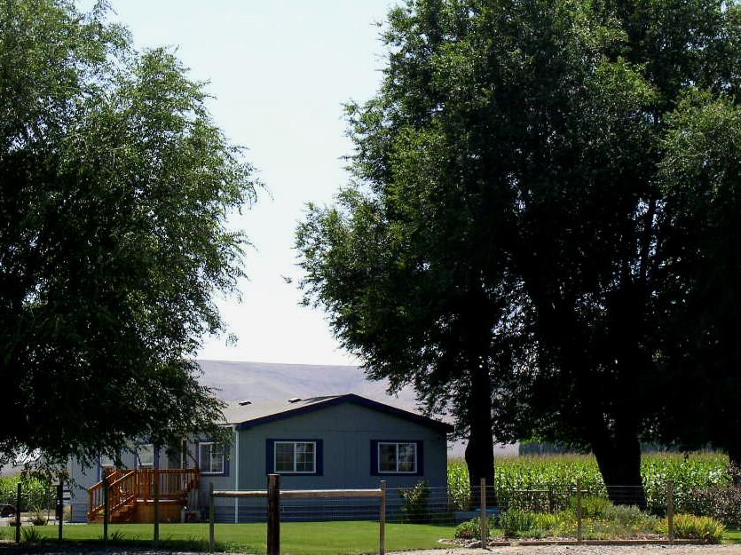 8190 Campbell Road Toppenish, WA 98948 - Photo 14 of 18 a front view of a house with a garden and tree