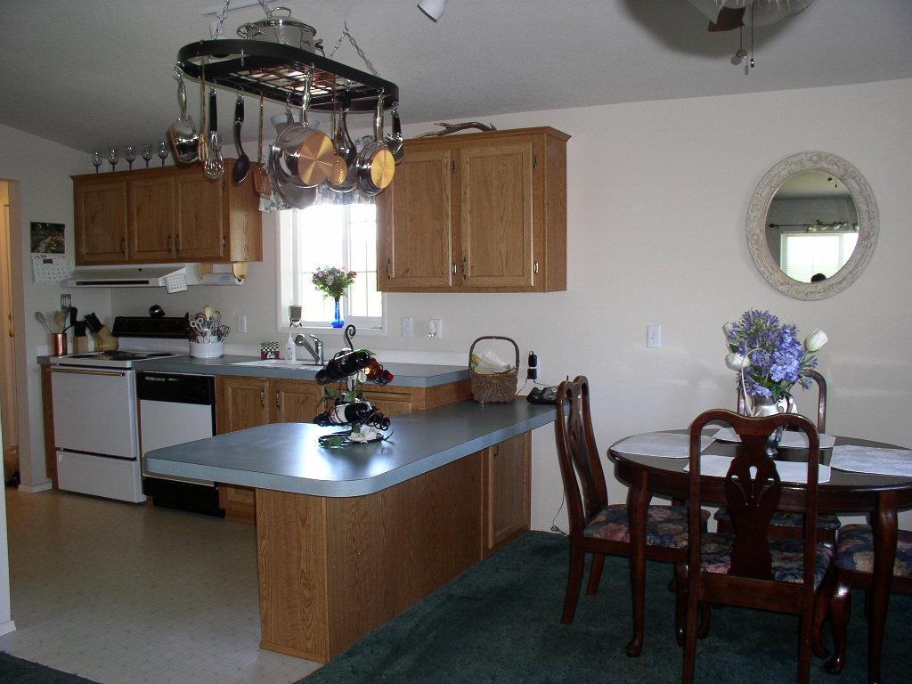 8190 Campbell Road Toppenish, WA 98948 - Photo 8 of 18 a kitchen with stainless steel appliances a dining table chairs and stove