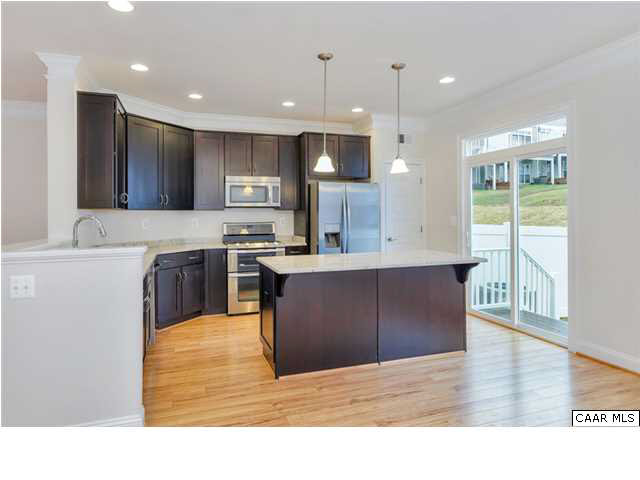 2315 Avinity Loop Charlottesville, VA 22902 - Photo 12 of 23 a kitchen with kitchen island a stove a sink a refrigerator and a counter top space