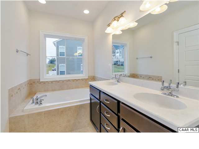 2315 Avinity Loop Charlottesville, VA 22902 - Photo 14 of 23 a bathroom with a sink a bathtub a mirror and a shower