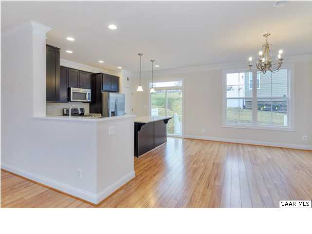 2315 Avinity Loop Charlottesville, VA 22902 - Photo 5 of 23 a open kitchen with stainless steel appliances granite countertop a refrigerator a sink dishwasher a stove and a dining table with wooden floor