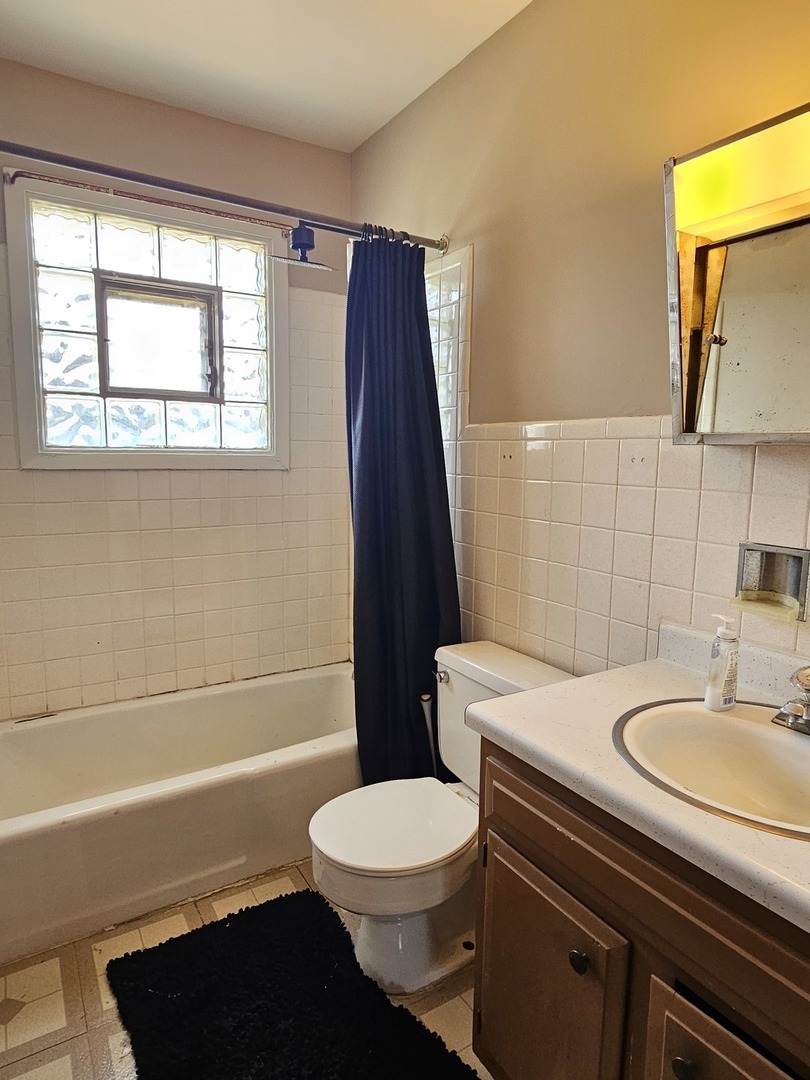 1335 Abbott Drive, Unit 5 Elgin, IL 60123 - Photo 8 of 10 a bathroom with a sink a toilet a mirror and shower