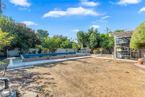a view of a yard with plants and trees