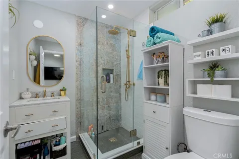 a bathroom with a sink a toilet and shower
