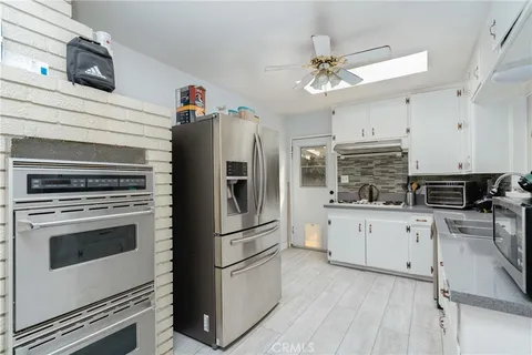 a kitchen with granite countertop a refrigerator oven a sink and dishwasher