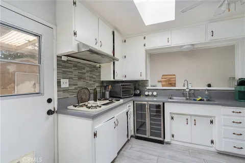 a kitchen with granite countertop a sink stove and cabinets