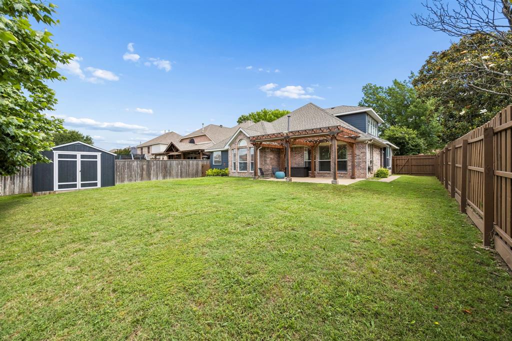 9217 Inverness Drive Rowlett, TX 75089 - Photo 28 of 40 Private Backyard with Storage Shed — A spacious fenced yard, storage shed, and covered patio area give you room for outdoor living, storage, and everyday convenience.