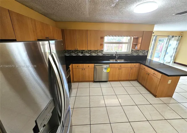 a kitchen with stainless steel appliances a refrigerator sink and cabinets