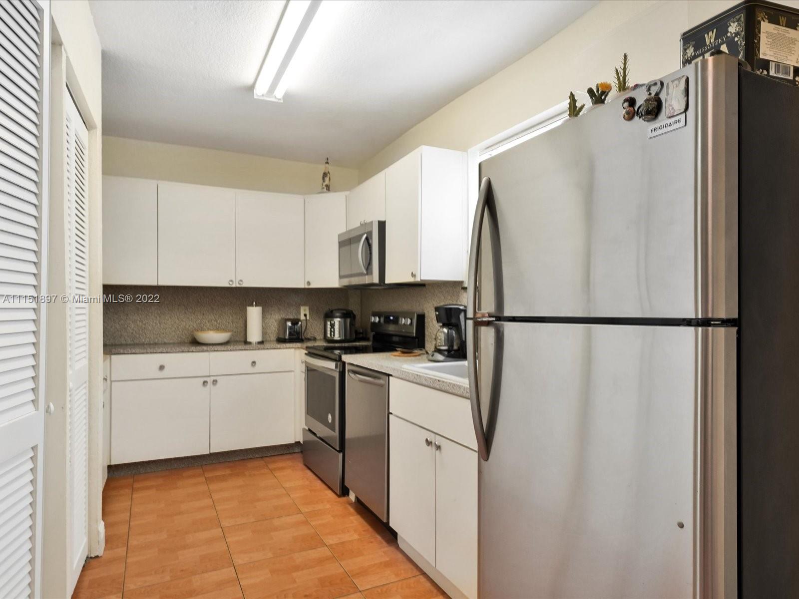 23 Northeast 46th Street Miami, FL 33137 - Photo 12 of 27 a kitchen with white cabinets and white appliances