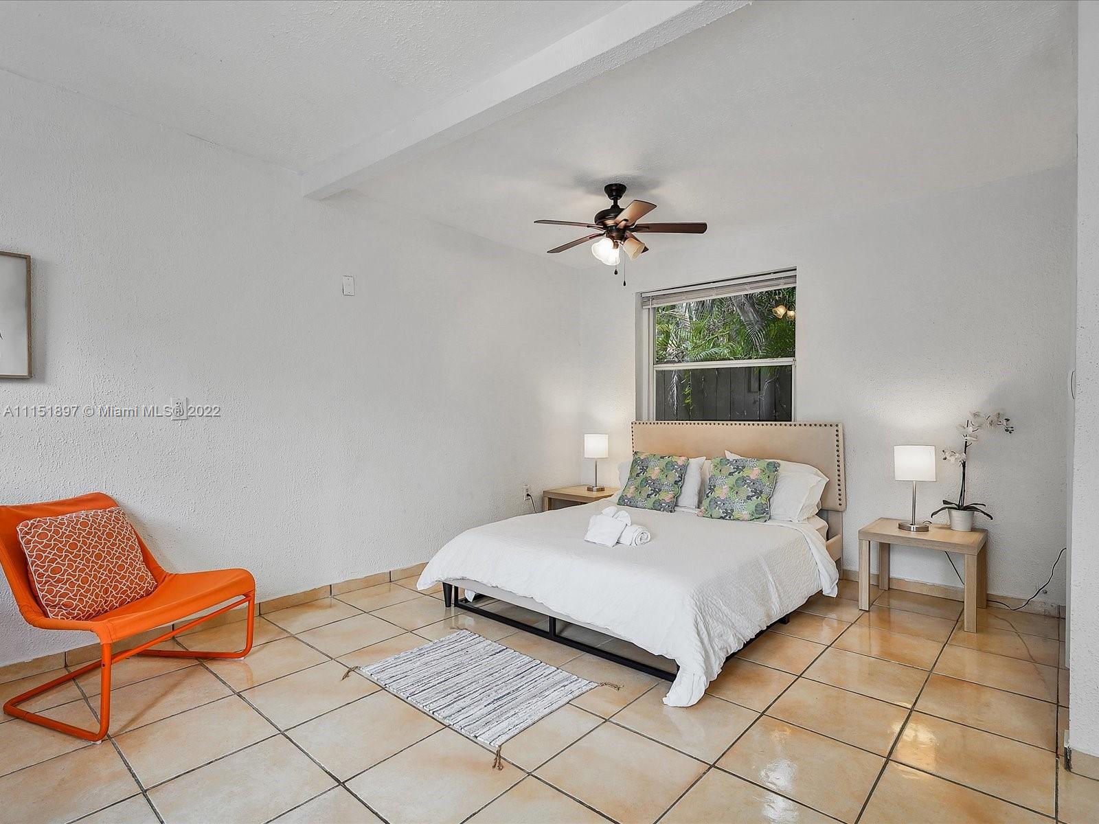 23 Northeast 46th Street Miami, FL 33137 - Photo 21 of 27 a bedroom with a bed and a chair