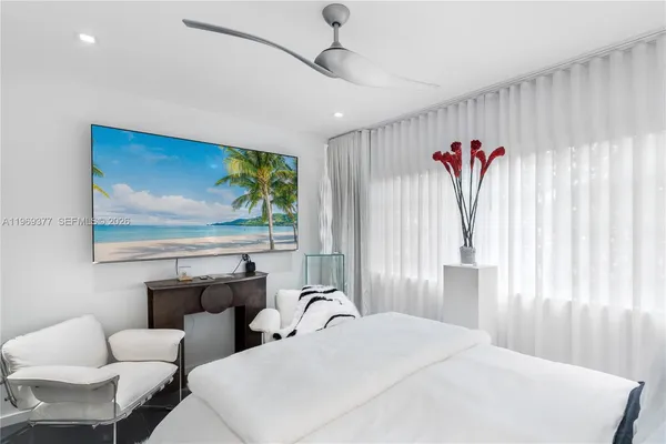 a bedroom with furniture and a large window