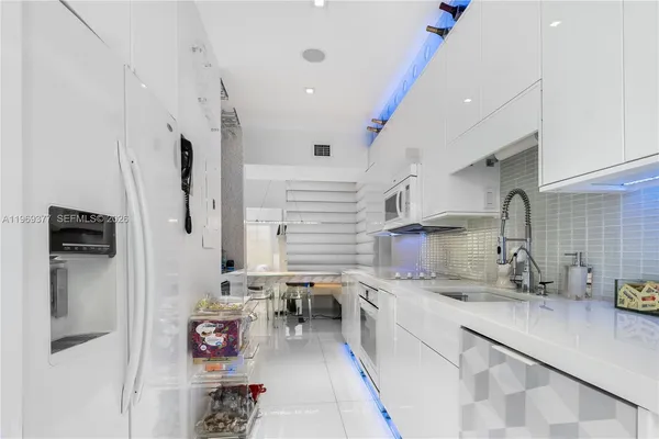 a kitchen with stainless steel appliances granite countertop a sink refrigerator and cabinets