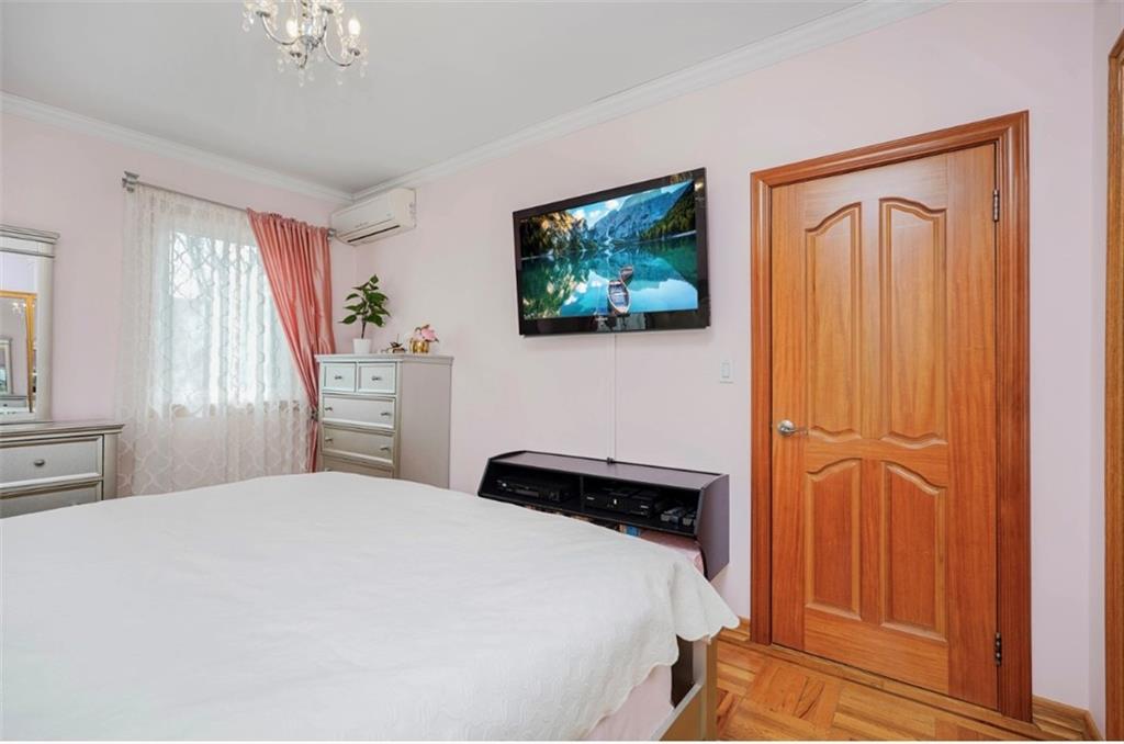 2623 Ave Y Brooklyn, NY 11235 - Photo 18 of 35 a bedroom with a bed and a chandelier