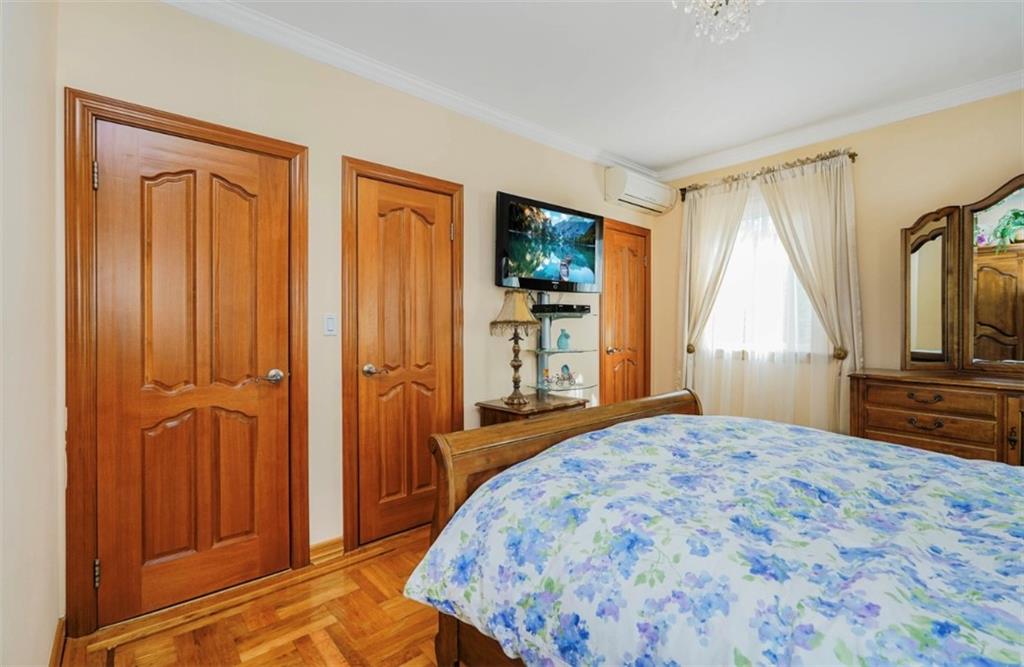 2623 Ave Y Brooklyn, NY 11235 - Photo 22 of 35 a bedroom with a bed and a dresser with mirror