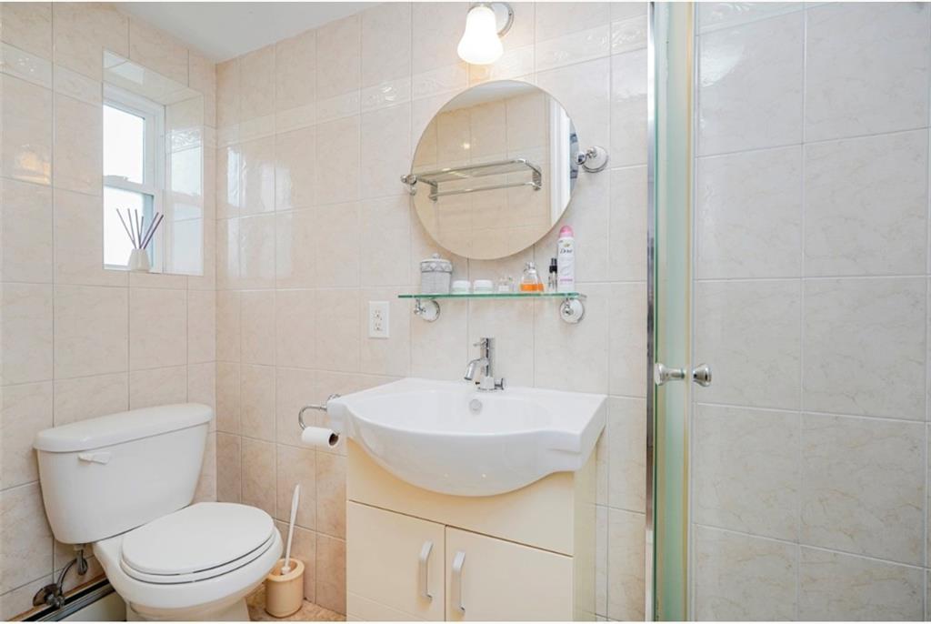 2623 Ave Y Brooklyn, NY 11235 - Photo 27 of 35 a bathroom with a sink a mirror and a toilet
