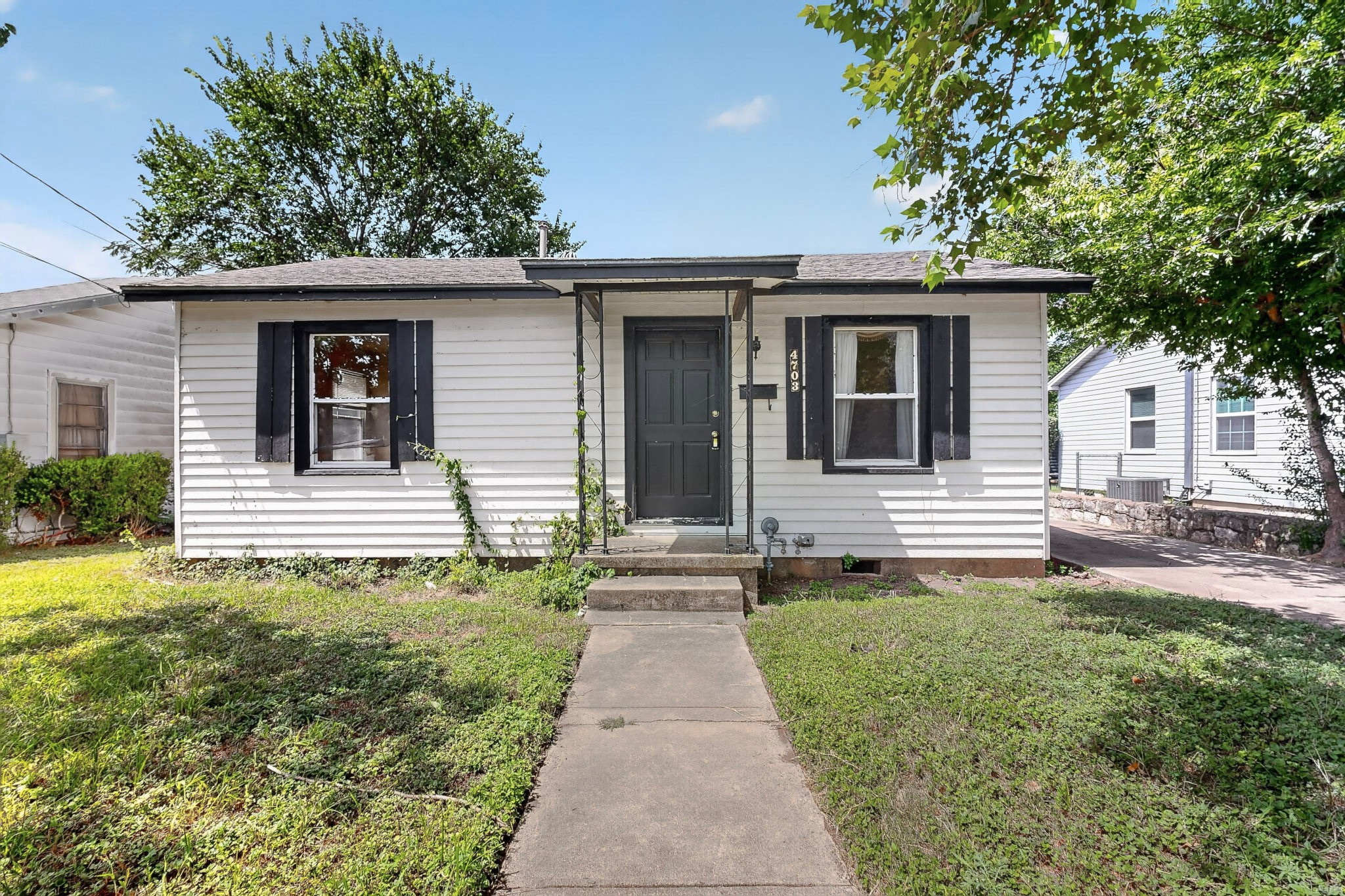 4703 Leslie Avenue Austin, TX 78721 - Photo 4 of 34 A classic facade with white siding and dark accents welcomes you to this inviting home.