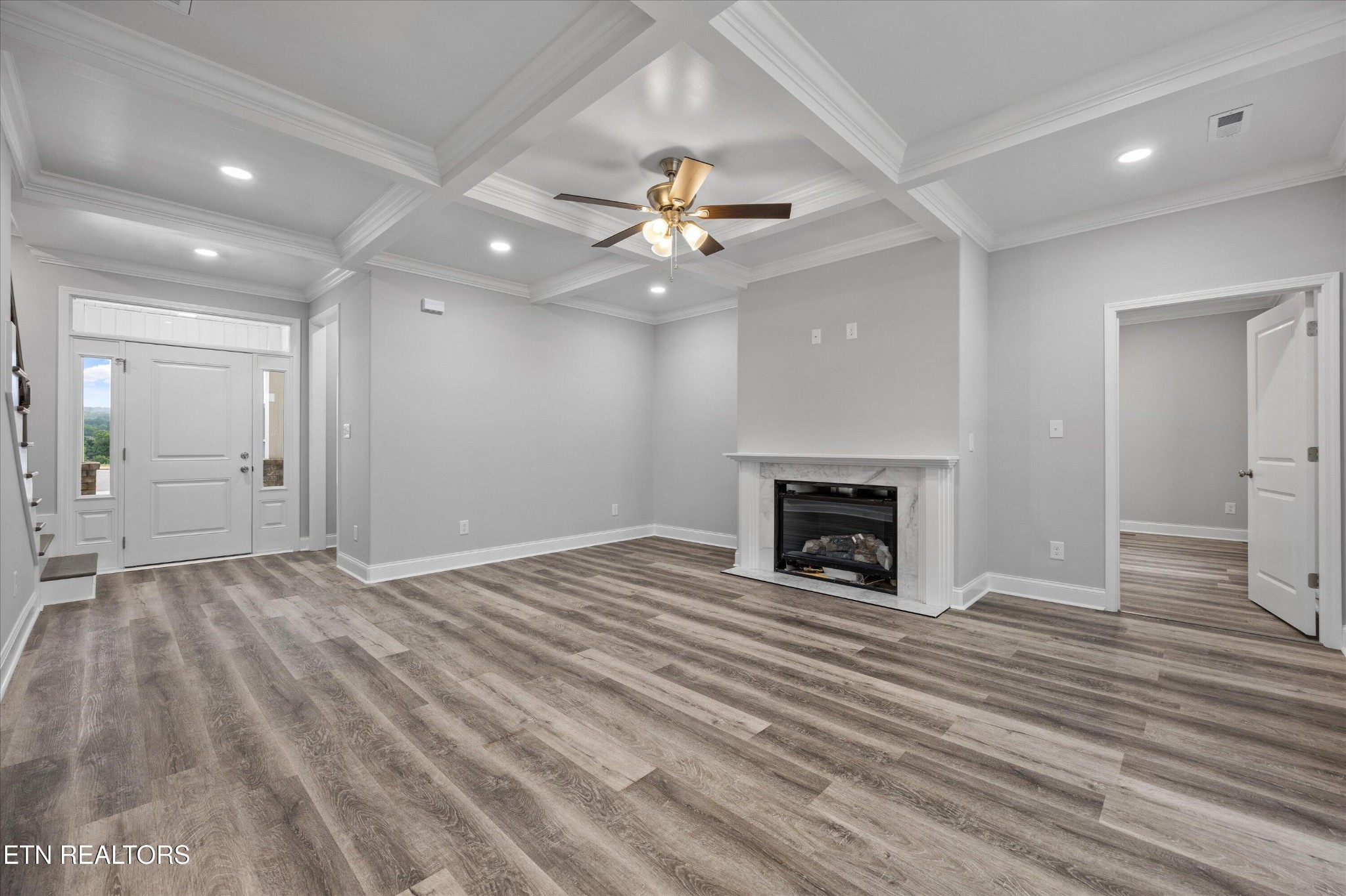 5649 Belle Maison Lane Knoxville, TN 37920 - Photo 8 of 42 a view of an empty room with a fireplace and a chandelier fan
