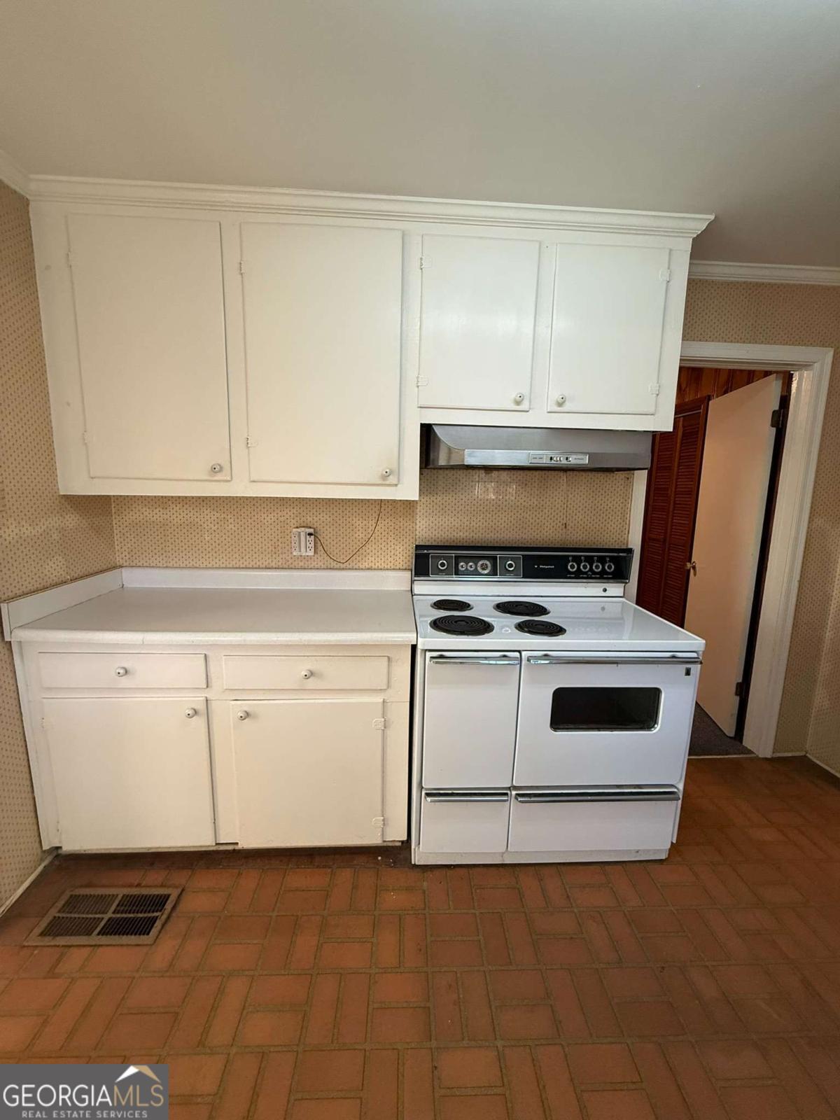 109 Vernon Street Dublin, GA 31021 - Photo 15 of 48 a kitchen with white cabinets and white appliances