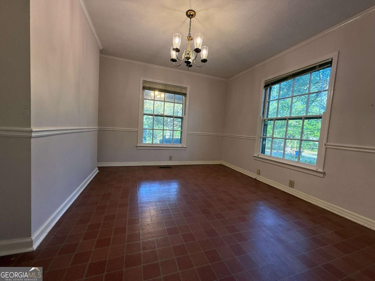 109 Vernon Street Dublin, GA 31021 - Photo 21 of 48 an empty room with wooden floor chandelier and windows